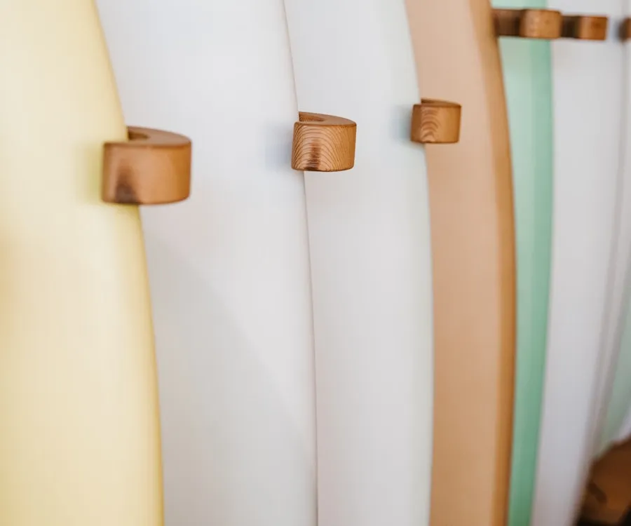 A row of well-used longboards against a wall